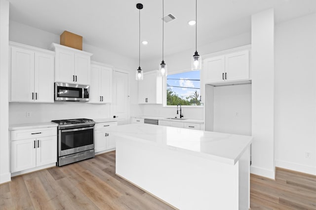 4124 Bucks St, Houston, TX 77020 - kitchen featuring stainless steel appliances, light wood-style floors, white cabinets, and recessed lighting