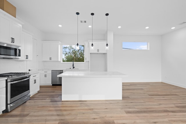 kitchen featuring white cabinetry, stainless steel appliances, and a kitchen island