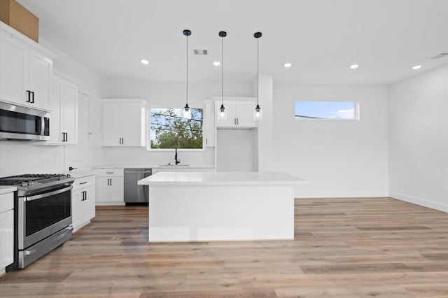4124 Bucks St, Houston, TX 77020 - kitchen featuring appliances with stainless steel finishes, white cabinetry, light countertops, a kitchen island, and recessed lighting
