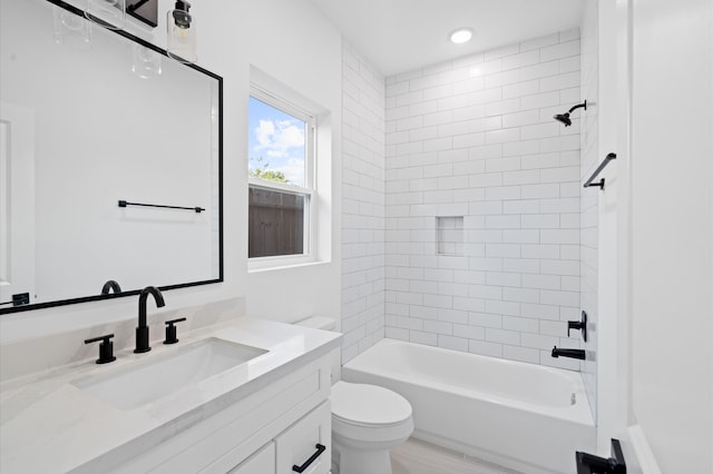 full bathroom with tiled shower / bath, vanity, and toilet