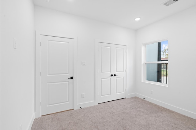 unfurnished bedroom with light colored carpet