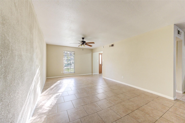 tiled spare room with a textured ceiling and ceiling fan