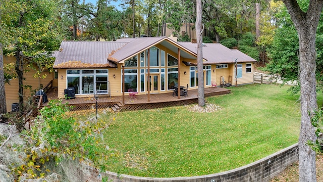 back of house with a deck and a lawn