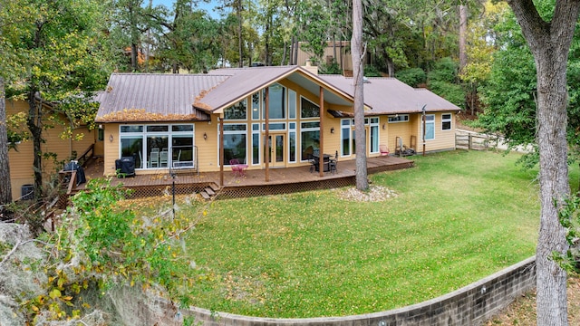 back of house featuring a yard, metal roof, a wooden deck, and fence
