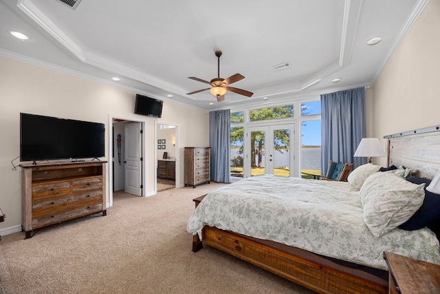 carpeted bedroom with ensuite bath, ornamental molding, ceiling fan, and a tray ceiling