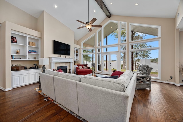 living room with beam ceiling, ceiling fan, dark hardwood / wood-style flooring, high vaulted ceiling, and a fireplace