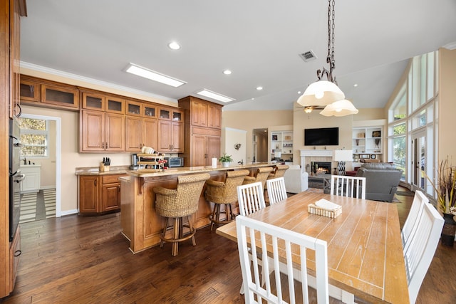 dining room featuring lofted ceiling, dark wood-type flooring, and a healthy amount of sunlight