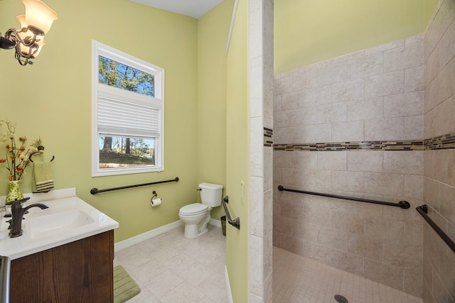 bathroom featuring toilet, vanity, and tiled shower