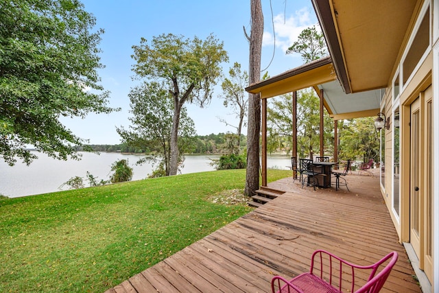 deck with a water view and a yard