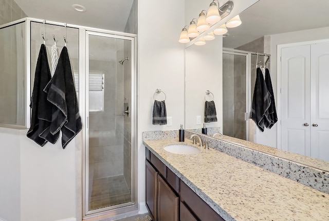 bathroom with a shower with door and vanity