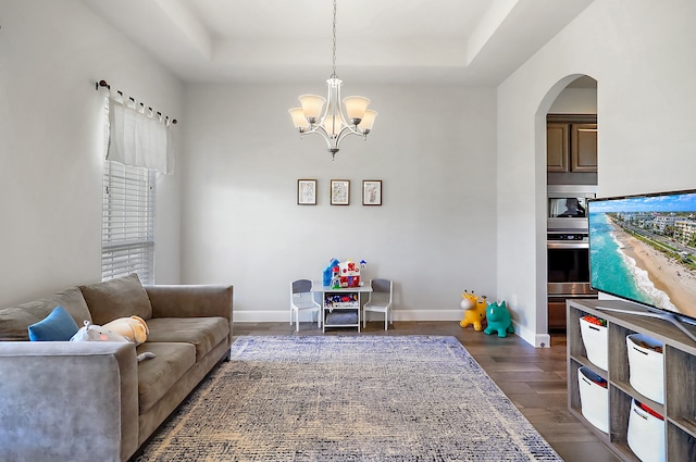 living room with a notable chandelier and dark wood-type flooring