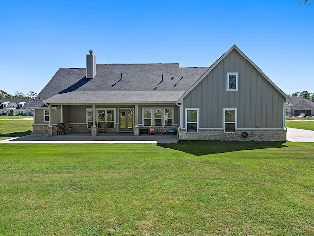 rear view of property featuring a lawn