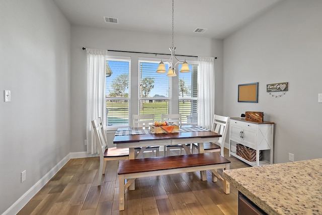 dining space featuring hardwood / wood-style floors and a chandelier