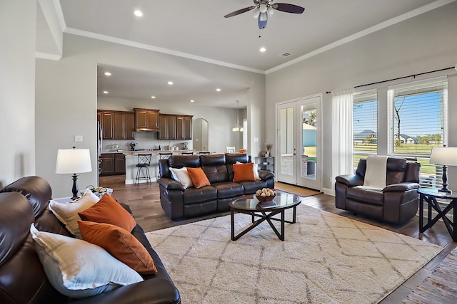 living room featuring hardwood / wood-style floors, ceiling fan, and ornamental molding