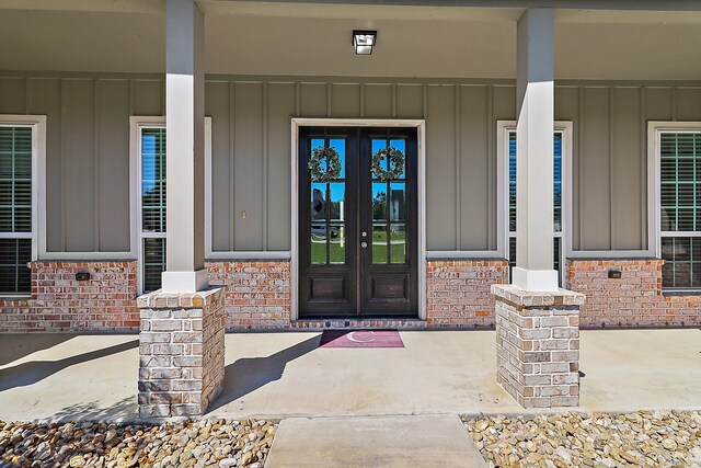 entrance to property featuring covered porch and french doors