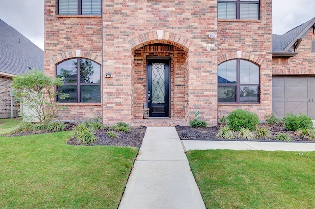 view of exterior entry featuring a yard