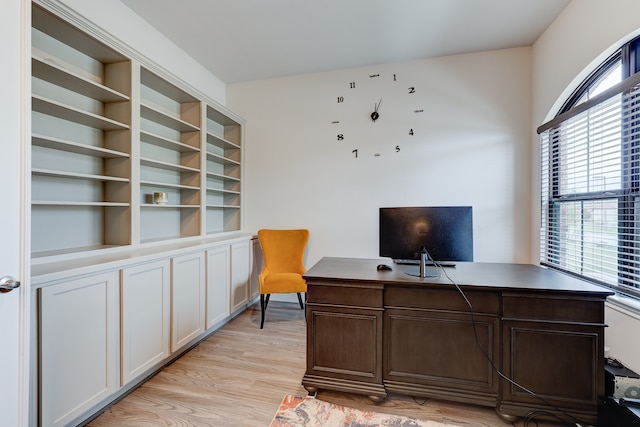 home office with light hardwood / wood-style flooring