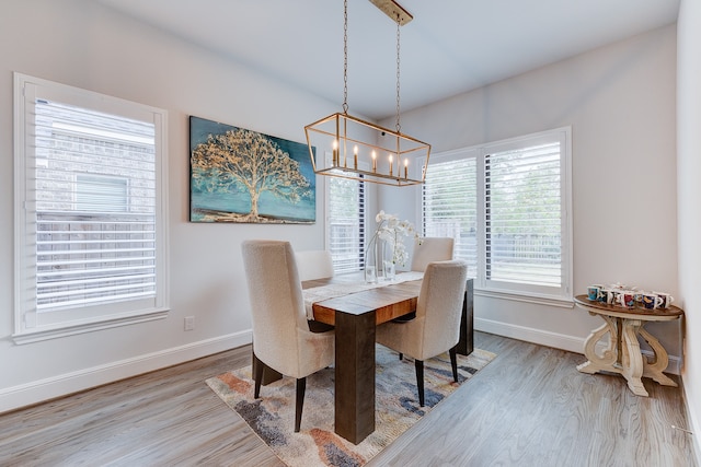 dining space featuring light hardwood / wood-style floors and an inviting chandelier