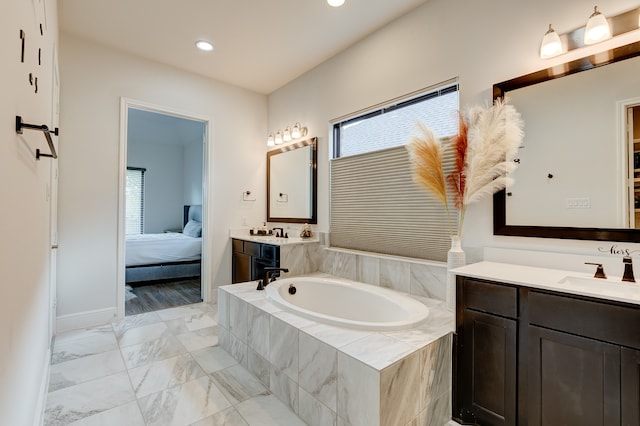 bathroom featuring vanity and tiled tub