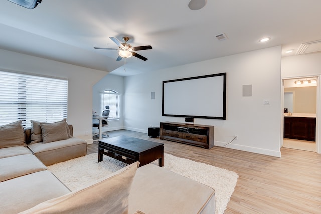 home theater with ceiling fan and light hardwood / wood-style flooring