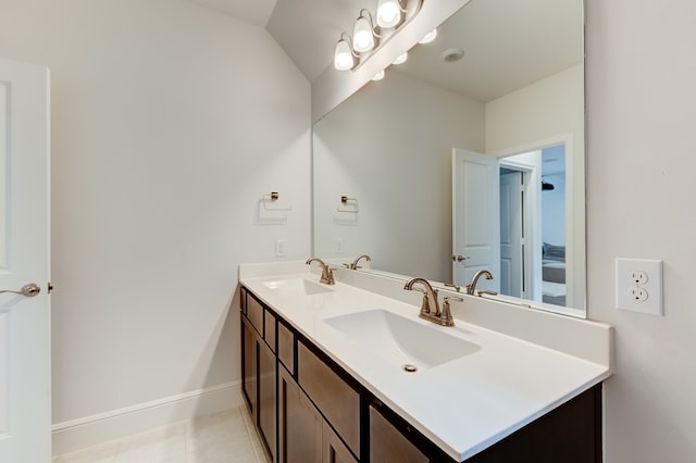 bathroom with tile patterned flooring, vanity, and lofted ceiling