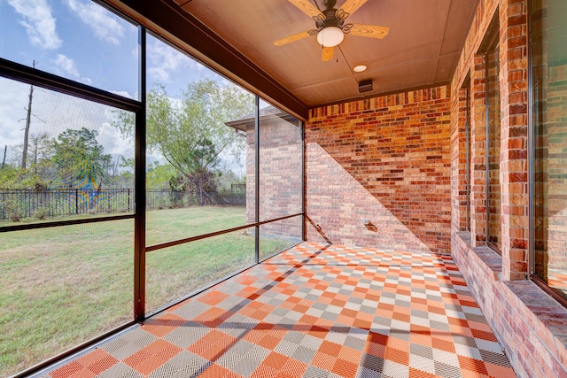 unfurnished sunroom with ceiling fan