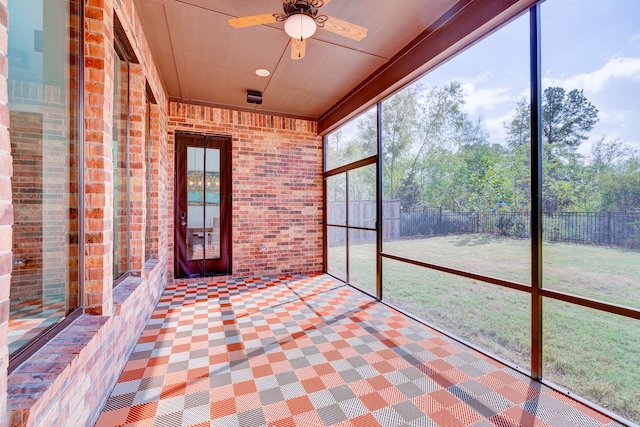 unfurnished sunroom featuring ceiling fan