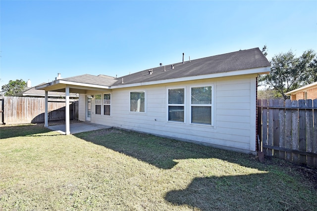 rear view of property with a yard and a patio area