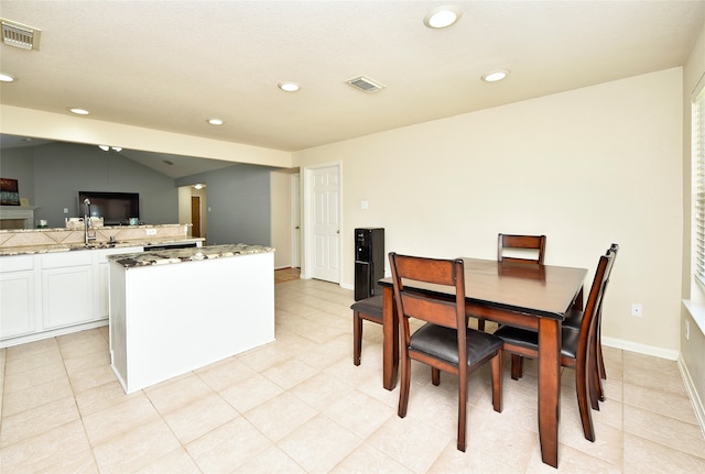 tiled dining space with lofted ceiling