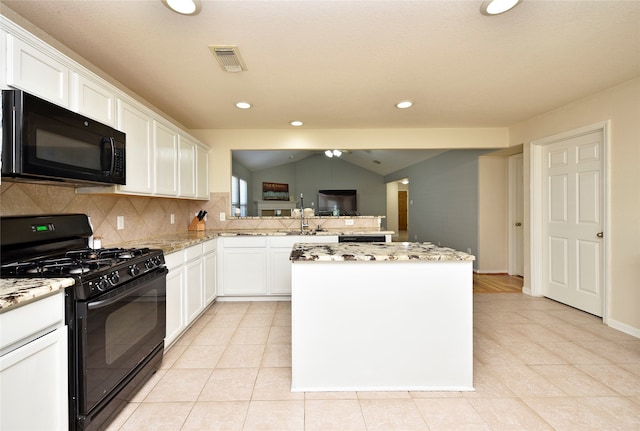 kitchen featuring black appliances, white cabinets, vaulted ceiling, decorative backsplash, and a kitchen island