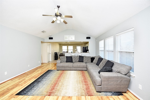 living room with hardwood / wood-style flooring, ceiling fan, and lofted ceiling