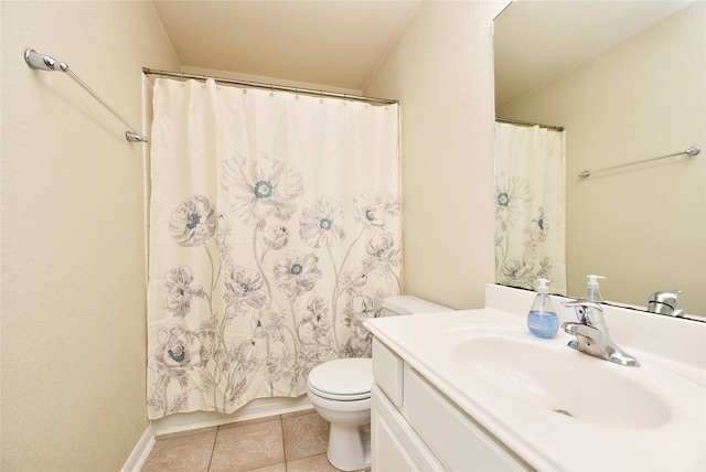 bathroom with toilet, vanity, and tile patterned floors