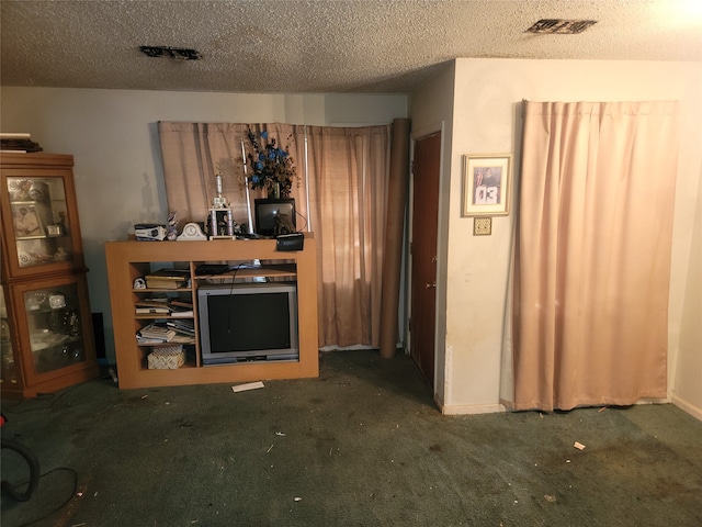 unfurnished living room featuring a textured ceiling and dark carpet