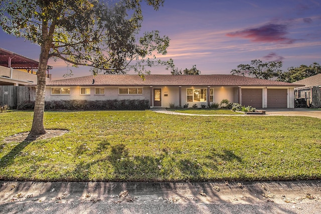 single story home with a lawn and a garage