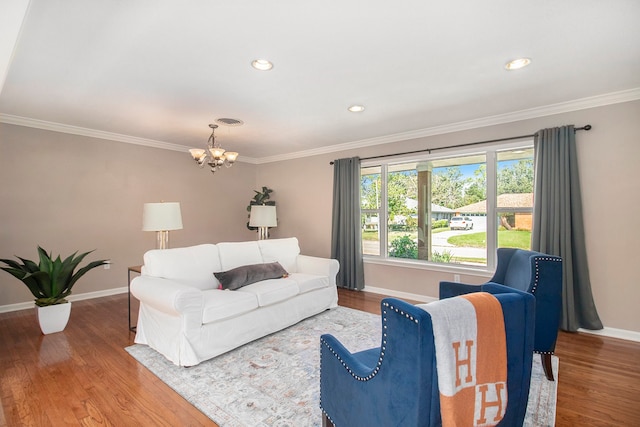 living room featuring hardwood / wood-style flooring, ornamental molding, and an inviting chandelier