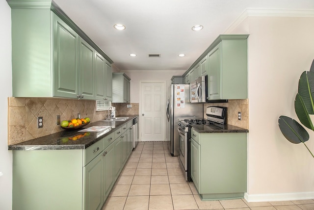 kitchen featuring tasteful backsplash, light tile patterned floors, ornamental molding, and appliances with stainless steel finishes