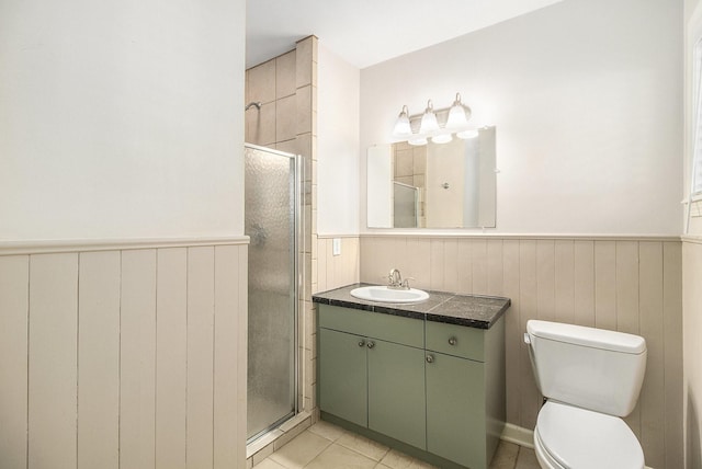 4837 Briarbend Dr, Houston, TX 77035 - bathroom featuring tile patterned flooring, toilet, wooden walls, a shower with door, and vanity
