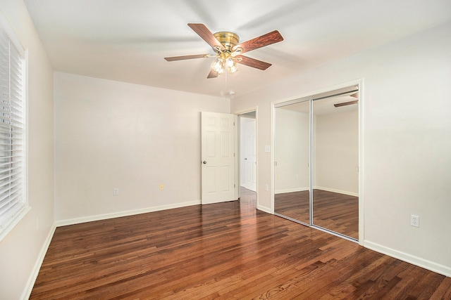 unfurnished bedroom with ceiling fan, a closet, and dark wood-type flooring