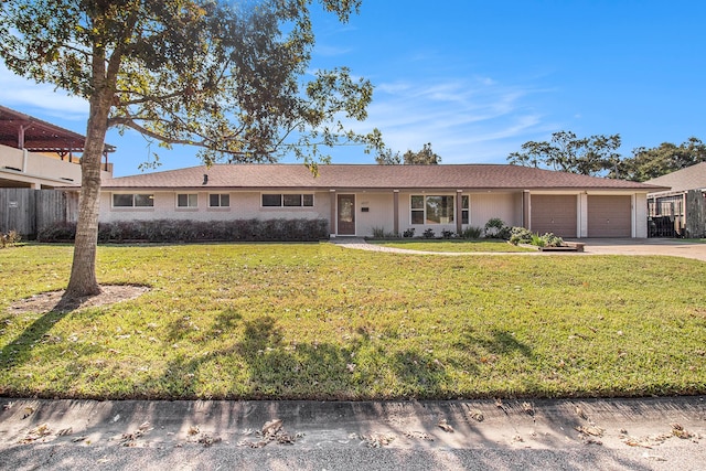 ranch-style house featuring a front yard and a garage