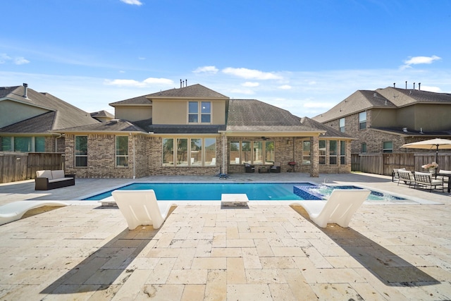 view of pool with a patio area, a pool with connected hot tub, and fence