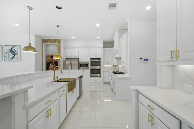 kitchen featuring appliances with stainless steel finishes, light stone counters, ornamental molding, white cabinetry, and hanging light fixtures