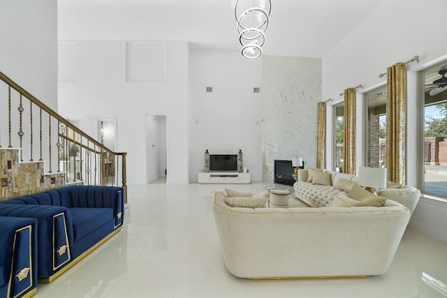 living room with light tile patterned flooring, a high ceiling, and a high end fireplace