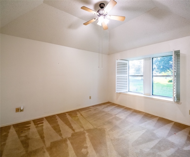 empty room featuring carpet flooring, ceiling fan, and vaulted ceiling