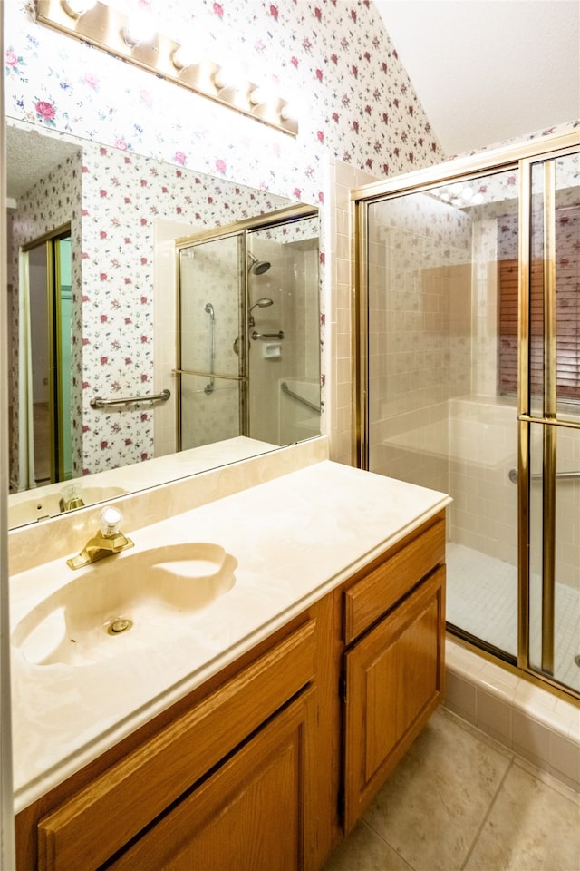 bathroom with tile patterned flooring, vanity, and walk in shower