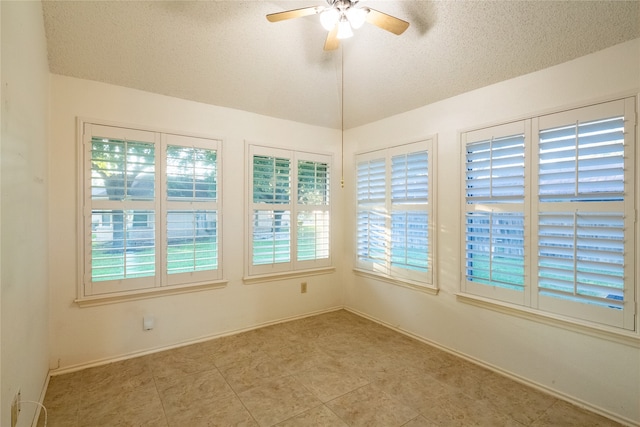 spare room featuring a textured ceiling, plenty of natural light, and ceiling fan