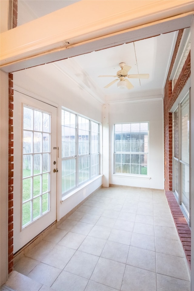 unfurnished sunroom with ceiling fan