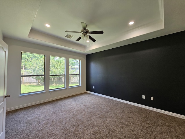 unfurnished room with carpet, ceiling fan, and a tray ceiling