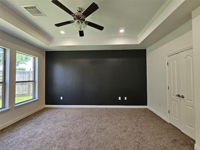 spare room featuring carpet flooring, a tray ceiling, ceiling fan, and ornamental molding