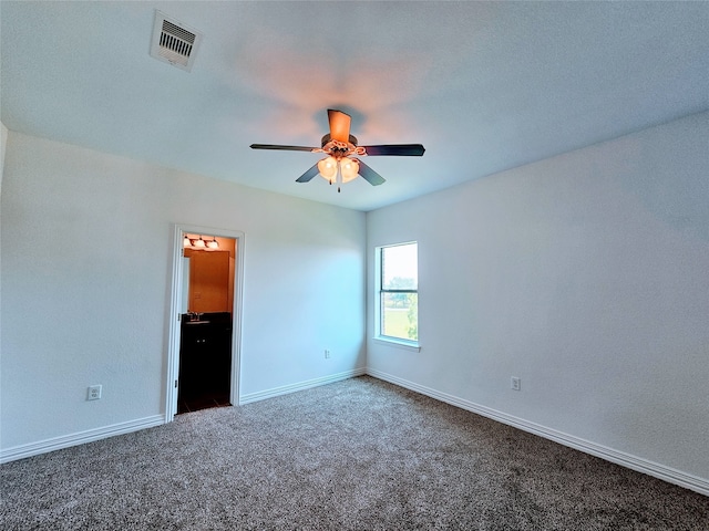 unfurnished room with ceiling fan and dark carpet