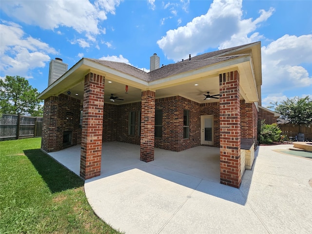 back of property featuring a yard, ceiling fan, and a patio area